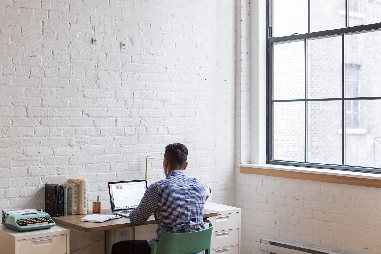 person sitting and working remotely at a desk