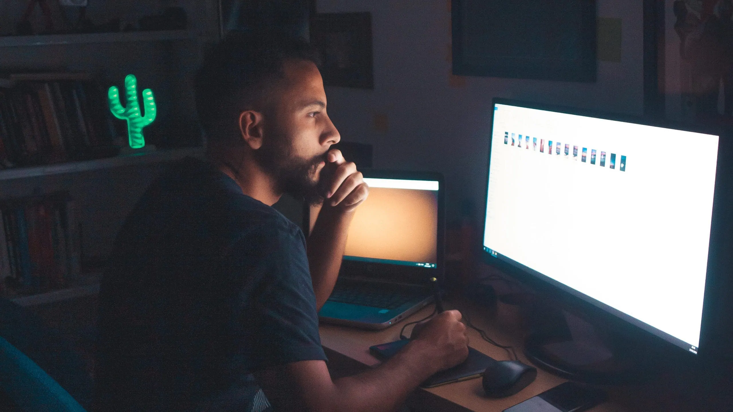 An outsourced freelance remote professional works from his computer at night